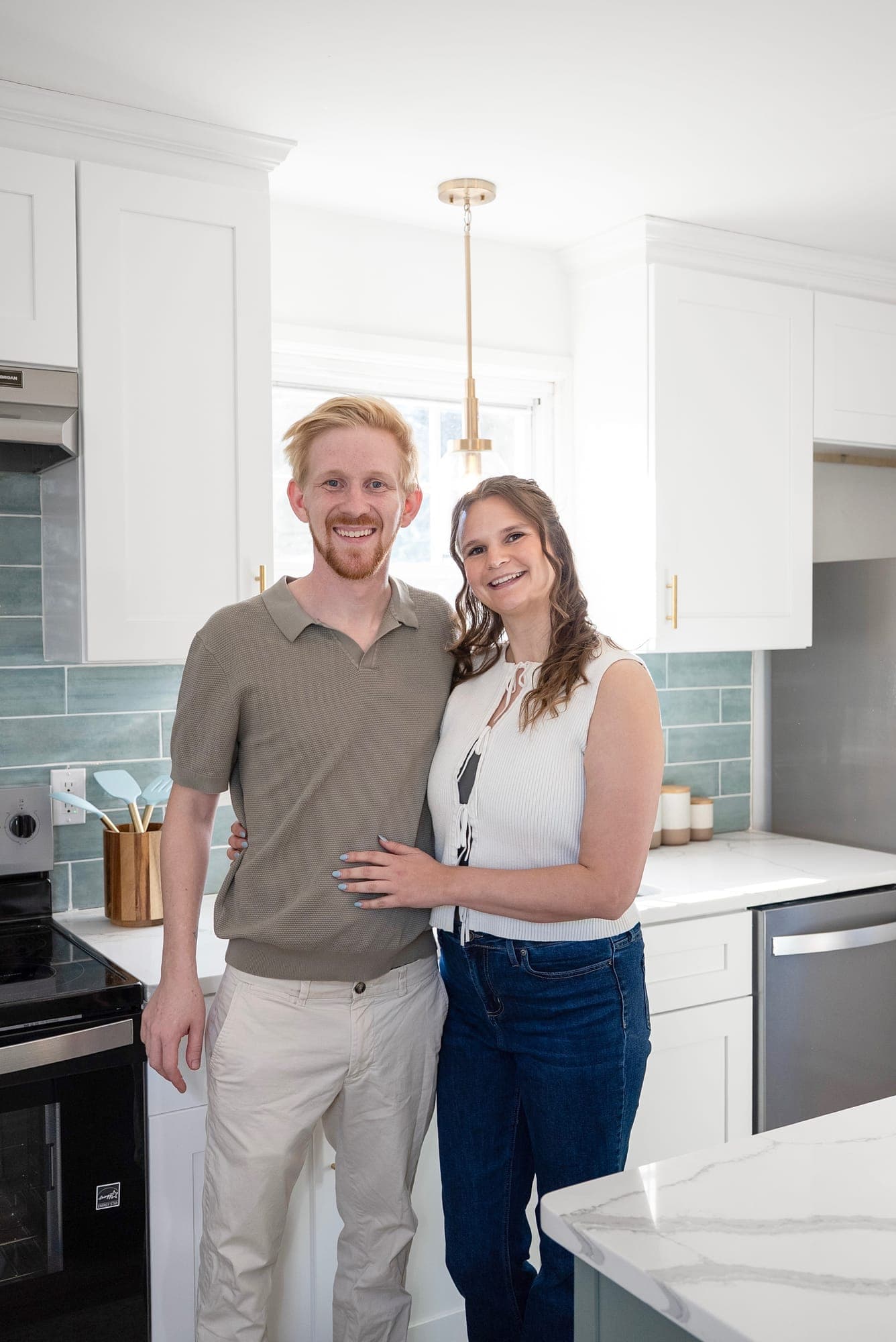 Mel and Scott, owners of The Punch Out Pros, smiling in a renovated kitchen